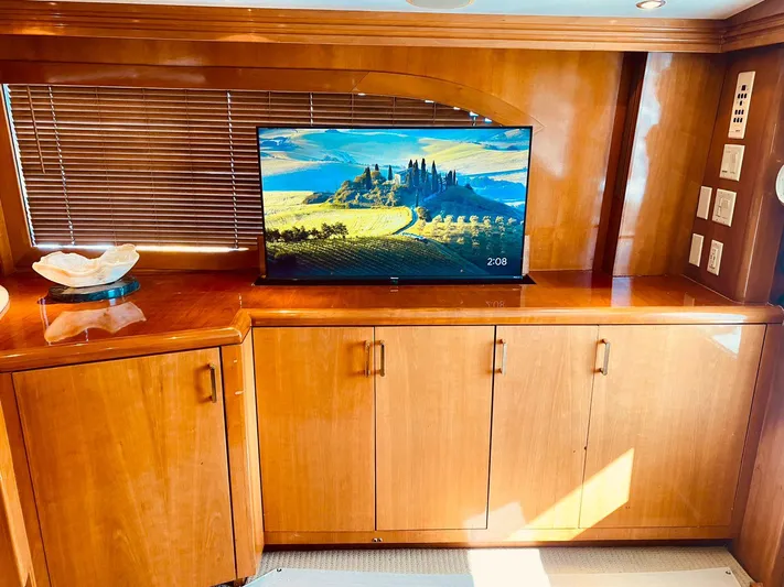  Yacht Photos Pics Luxurious interior of 2001 Hatteras 60 Convertible yacht with wooden cabinetry and flat-screen TV.