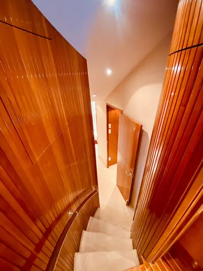  Yacht Photos Pics Interior staircase of 2001 Hatteras 60 Convertible yacht with polished wood finish.