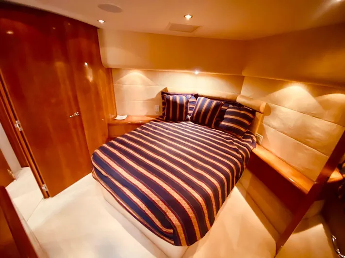  Yacht Photos Pics Luxurious cabin interior of 2001 Hatteras 60 Convertible yacht with striped bedding.