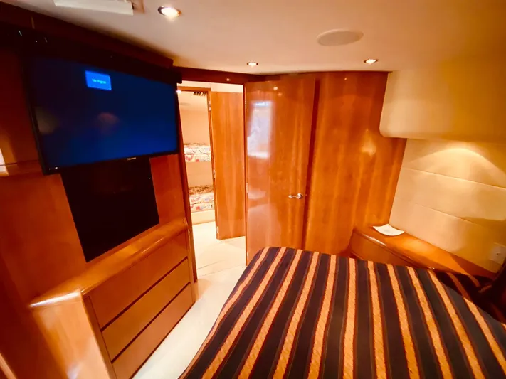  Yacht Photos Pics Luxurious cabin interior of 2001 Hatteras 60 Convertible yacht with wood finishes and TV.