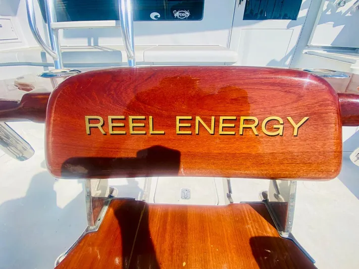  Yacht Photos Pics Wooden chair on 2001 Hatteras 60 Convertible yacht with "Reel Energy" inscription.
