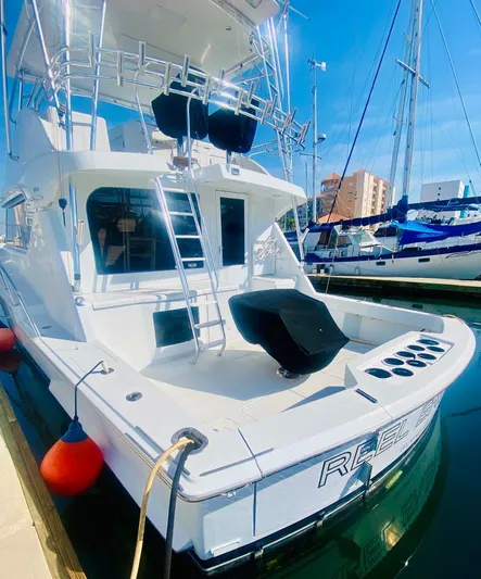  Yacht Photos Pics 2001 Hatteras 60 Convertible yacht docked in marina, featuring spacious deck and fishing equipment.