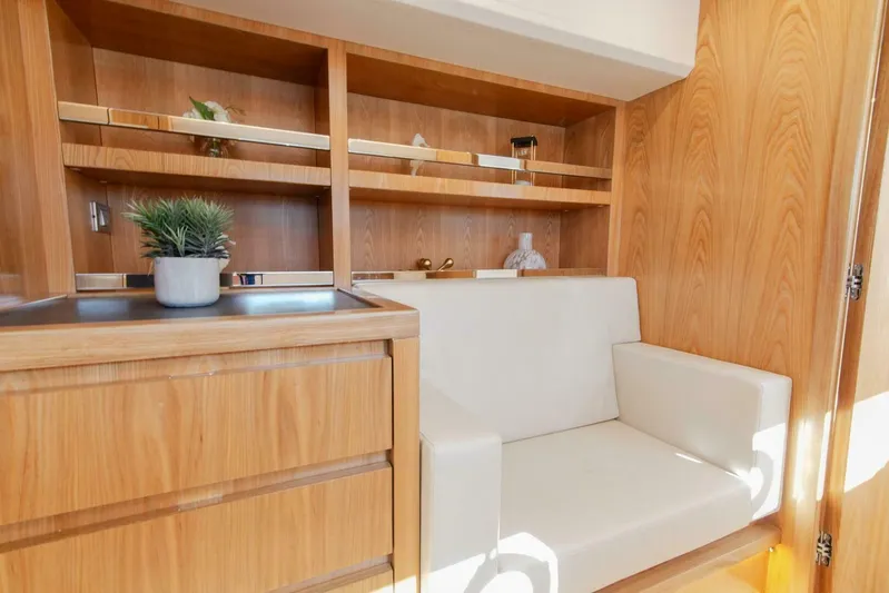 53e Iliad 2026 Yacht Photos Pics Modern yacht interior with wooden cabinetry, white seating, and decorative plant, ILIAD 53E, 2026 model.
