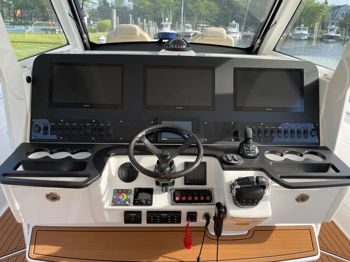 Yacht Photos Pics Control panel of 2019 Everglades 435 CC boat with multiple screens and steering wheel.