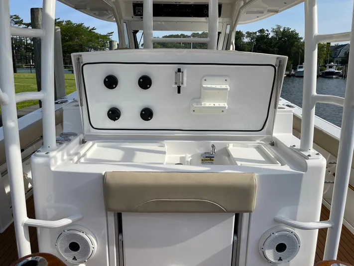  Yacht Photos Pics 2019 Everglades 435 CC boat console with storage and controls, docked by a scenic waterfront.
