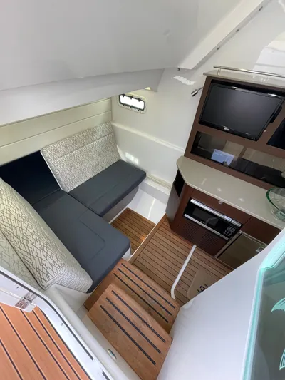  Yacht Photos Pics 2019 Everglades 435 CC cabin interior with seating, TV, and kitchenette.