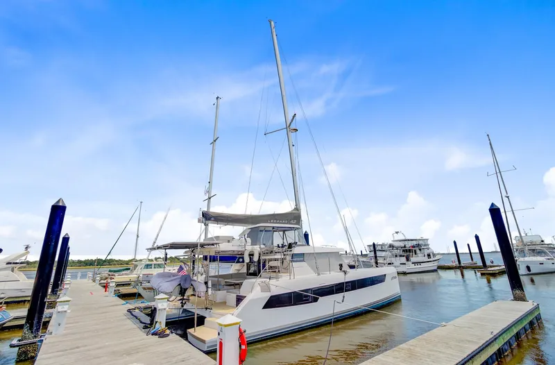Latidoods Yacht Photos Pics 2021 Leopard 42 catamaran docked at marina under clear blue sky.