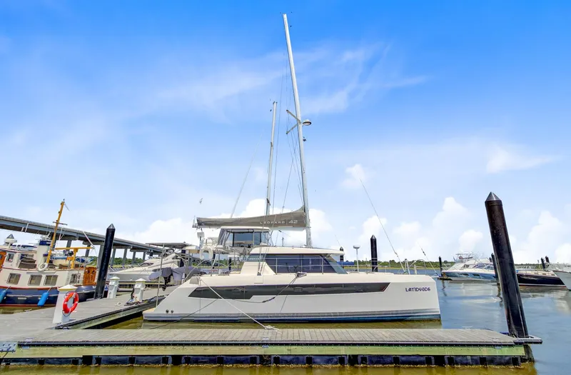 Latidoods Yacht Photos Pics 2021 Leopard 42 catamaran docked at marina under clear blue sky.