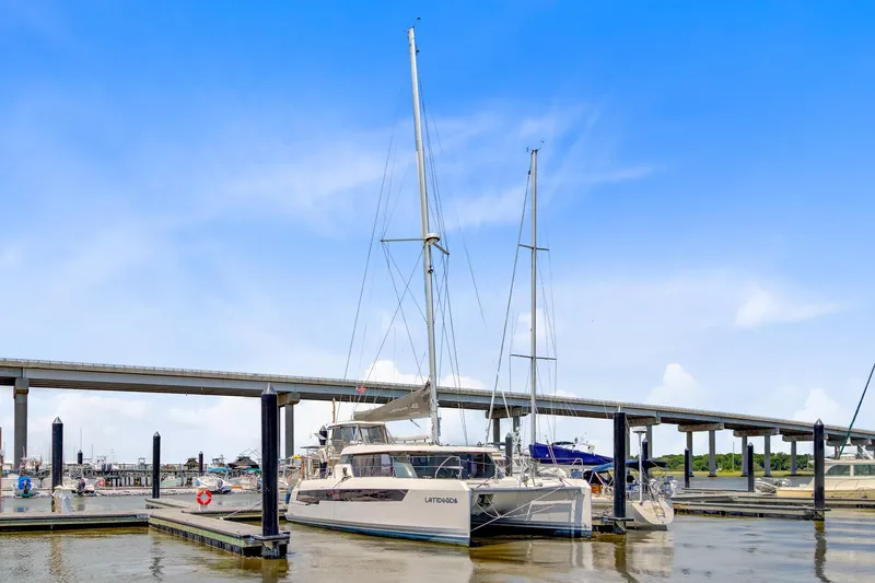 Latidoods Yacht Photos Pics 2021 Leopard 42 catamaran docked at marina under clear blue sky.