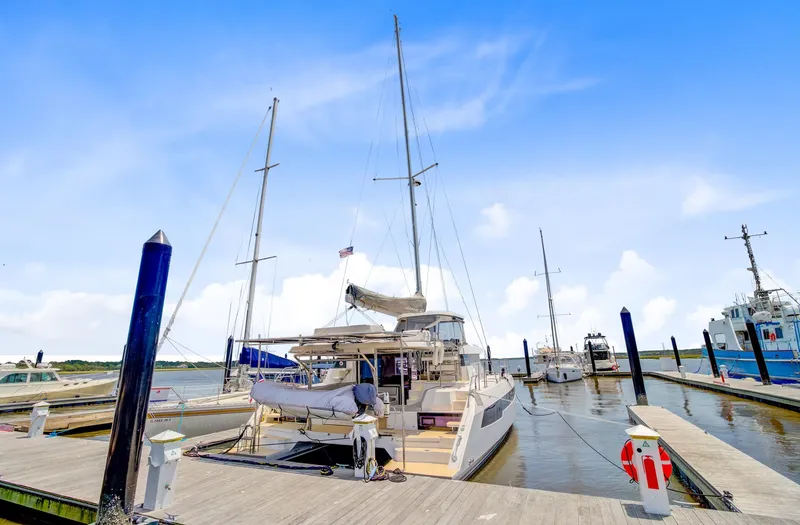 Latidoods Yacht Photos Pics 2021 Leopard 42 catamaran docked at marina under clear blue sky.