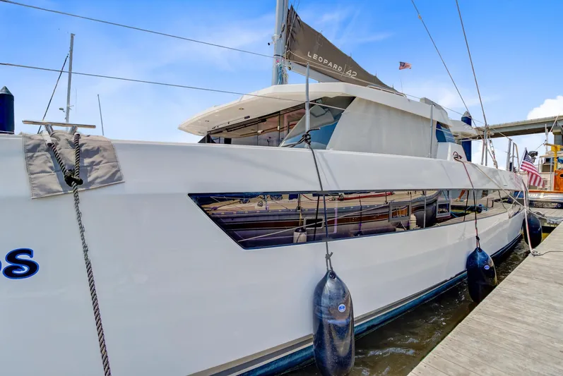 Latidoods Yacht Photos Pics 2021 Leopard 42 yacht docked at marina, sleek design, white hull, blue sky background.
