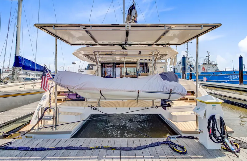 Latidoods Yacht Photos Pics 2021 Leopard 42 yacht docked with covered dinghy and American flag.