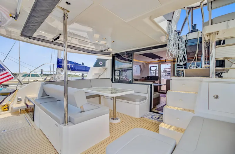 Latidoods Yacht Photos Pics Luxurious 2021 Leopard 42 yacht interior with seating, table, and stairs.