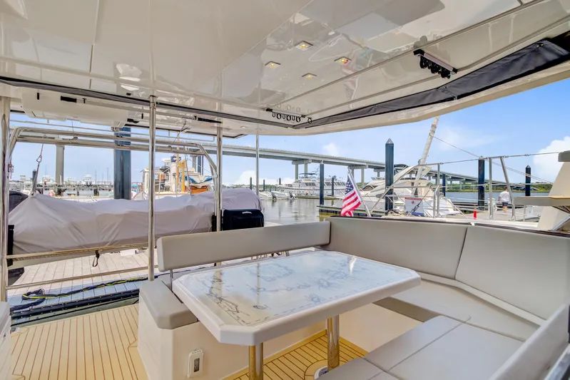Latidoods Yacht Photos Pics Luxurious Leopard 42 yacht interior with seating area, table, and marina view, 2021 model.