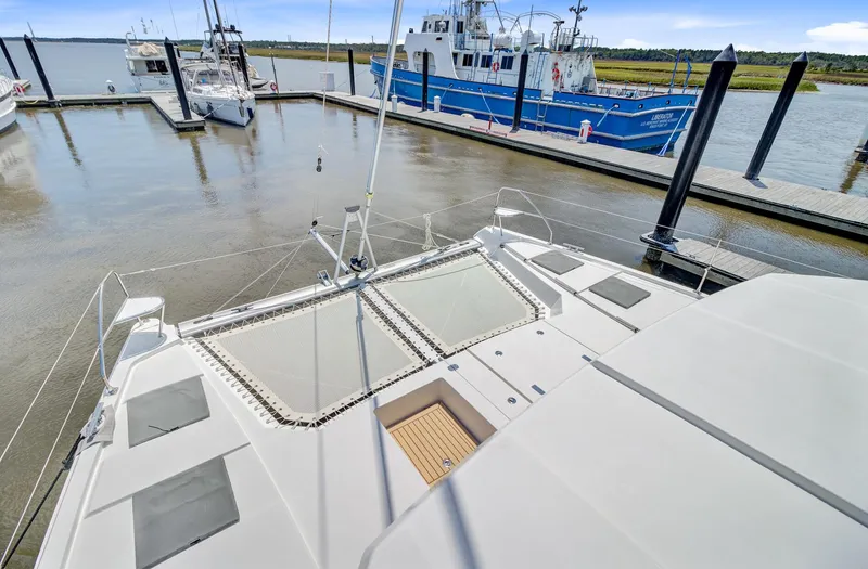 Latidoods Yacht Photos Pics Leopard 42 catamaran docked at marina, showcasing spacious deck and netting, 2021 model.