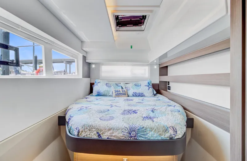 Latidoods Yacht Photos Pics Luxurious bedroom interior of 2021 Leopard 42 yacht with nautical-themed bedding.
