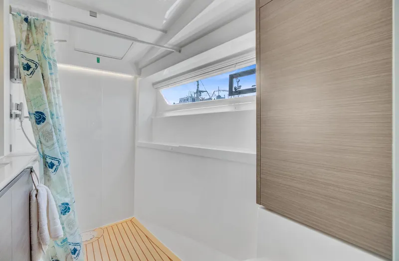 Latidoods Yacht Photos Pics Modern bathroom interior on Leopard 42 yacht, featuring wooden flooring and a window view.
