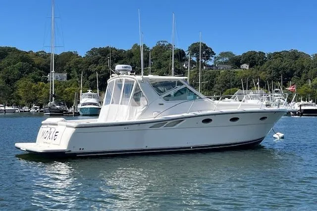 Moxie Yacht Photos Pics 1998 Tiara Yachts 3500 Open boat on calm water, surrounded by lush greenery and other vessels.