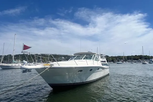 Moxie Yacht Photos Pics 1998 Tiara Yachts 3500 Open in a serene harbor setting under a clear blue sky.
