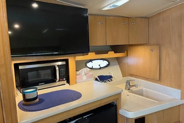 Moxie Yacht Photos Pics 1998 Tiara Yachts 3500 Open interior with kitchenette, TV, microwave, and sink.