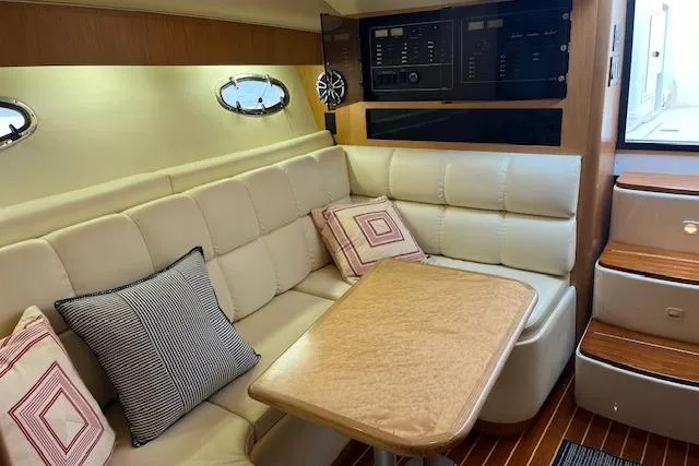 Moxie Yacht Photos Pics Interior of 1998 Tiara Yachts 3500 Open with beige seating and wooden table.