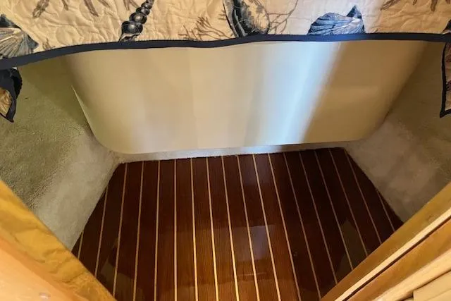 Moxie Yacht Photos Pics 1998 Tiara Yachts 3500 Open cabin interior with polished wood flooring and nautical-themed bedding.