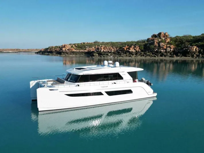 53s Iliad 2026 Yacht Photos Pics Luxurious 2026 ILIAD 53S yacht on serene water with rocky shoreline backdrop.