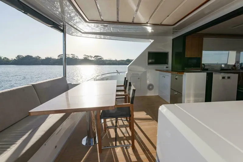 53s Iliad 2026 Yacht Photos Pics Luxurious ILIAD 53S yacht interior with dining area, overlooking serene water and sunset, 2026 model.