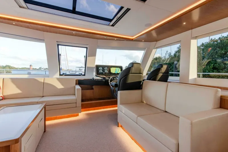53s Iliad 2026 Yacht Photos Pics Luxurious interior of 2026 ILIAD 53S yacht with modern seating and panoramic windows.
