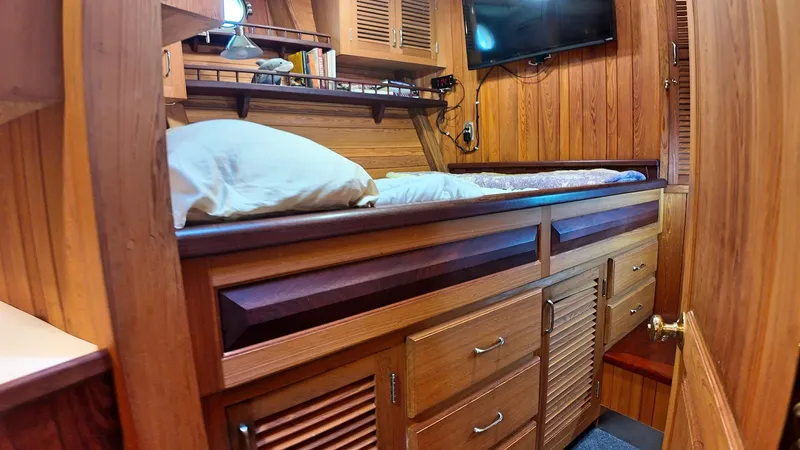 La Vita Marina Yacht Photos Pics Cozy wooden cabin interior of 1993 Holland Marine 50 Custom Trawler with bed and storage.