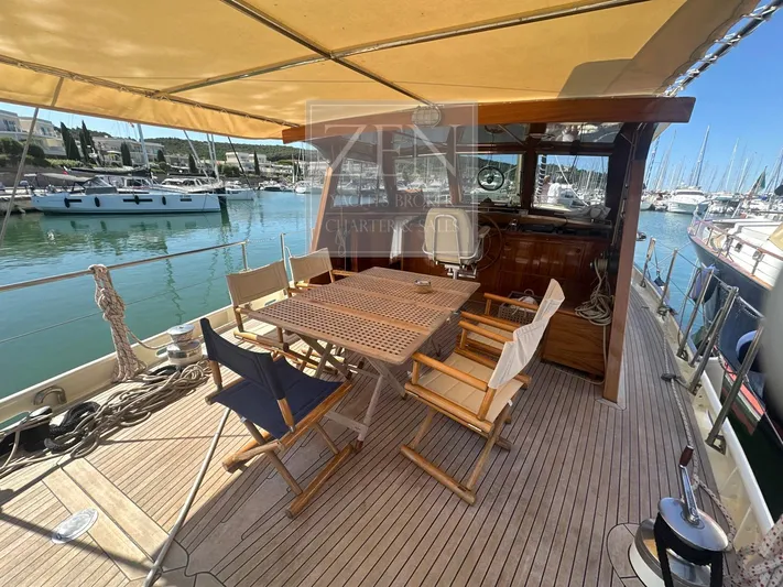  Yacht Photos Pics Deck of 1987 Galtarossa Motorsailer with wooden table and chairs, docked in marina.
