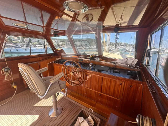  Yacht Photos Pics Luxurious wooden interior of 1987 Galtarossa Motorsailer, featuring helm and marina view.