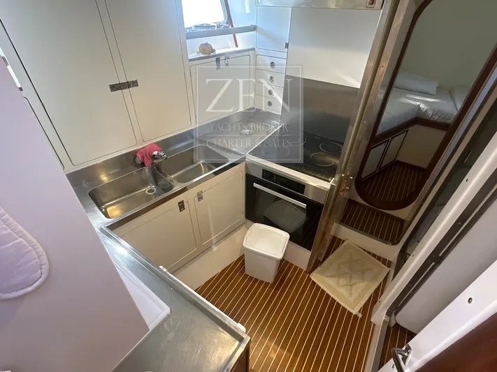  Yacht Photos Pics Compact kitchen in 1987 Galtarossa Motorsailer yacht with stainless steel sink and modern appliances.