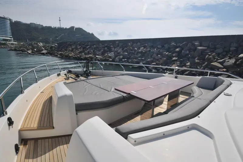  Yacht Photos Pics Luxurious 2017 Ferretti Yachts 850 with spacious deck seating and table, docked by rocky shore.