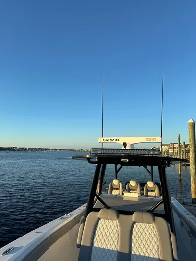 Main Event Yacht Photos Pics 2023 Front Runner 39 Center Console boat docked by calm waters under clear blue sky.