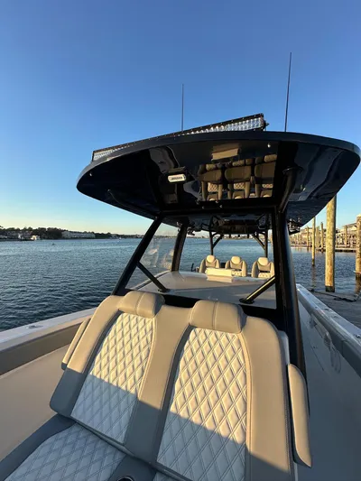 Main Event Yacht Photos Pics 2023 Front Runner 39 Center Console boat with luxurious seating, docked by the water.