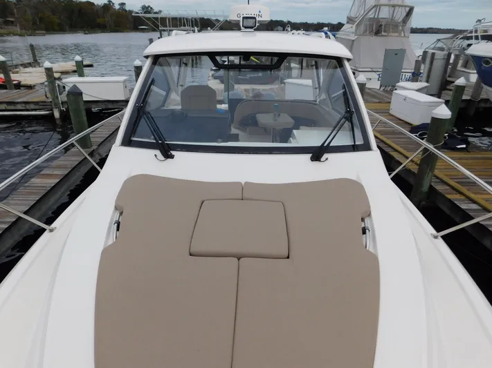  Yacht Photos Pics 2018 Pursuit OS 325 Offshore boat docked, featuring spacious deck and sleek design.