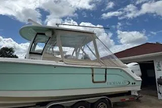  Yacht Photos Pics 2021 Robalo R300 Center Console boat on trailer under cloudy sky.