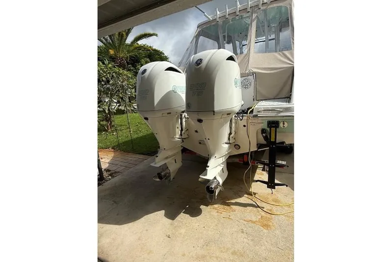  Yacht Photos Pics 2021 Robalo R300 Center Console with twin outboard engines in a driveway setting.
