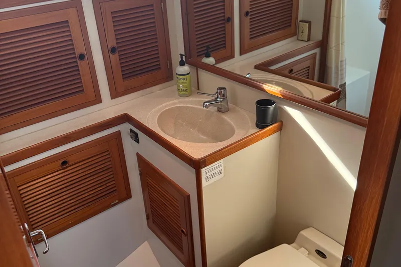  Yacht Photos Pics Bathroom interior of 1998 Kadey-Krogen 48' Northsea Widebody Pilothouse with wooden cabinetry.