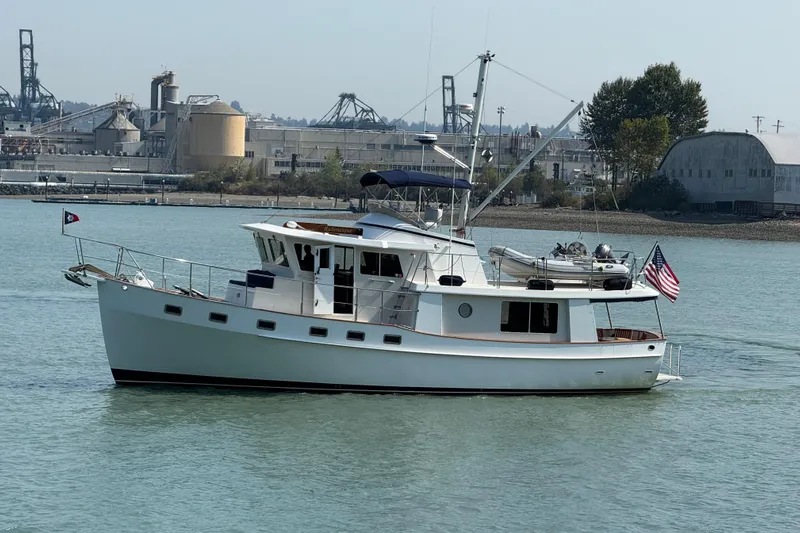  Yacht Photos Pics Kadey-Krogen 48' Northsea Widebody Pilothouse yacht, 1998, cruising on calm waters near industrial backdrop.