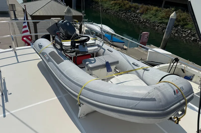  Yacht Photos Pics Inflatable boat on 1998 Kadey-Krogen 48' Northsea Widebody Pilothouse deck, docked by water.