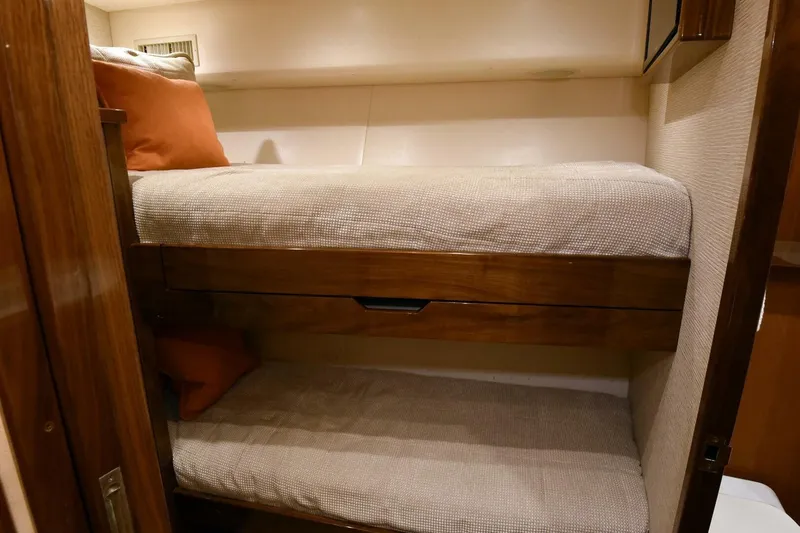 Party Of Five Yacht Photos Pics 2019 Viking 80 Sky Bridge yacht interior with cozy bunk beds and wooden accents.