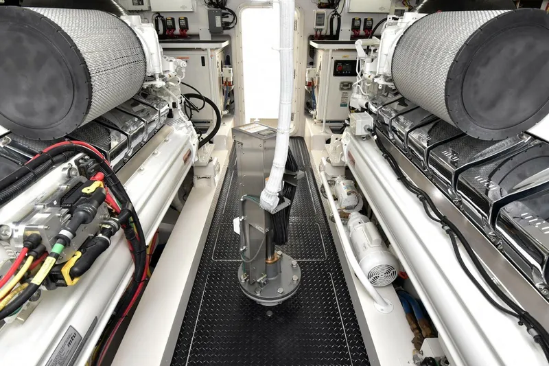 Party Of Five Yacht Photos Pics Engine room of 2019 Viking 80 Sky Bridge yacht, showcasing dual engines and intricate wiring.