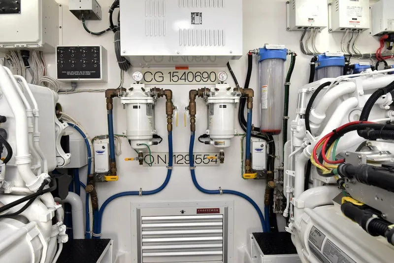 Party Of Five Yacht Photos Pics Engine room of 2019 Viking 80 Sky Bridge yacht, showcasing machinery and piping systems.