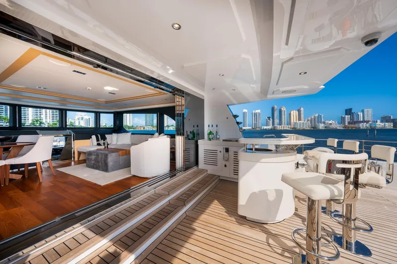 Santosh Yacht Photos Pics Luxurious 2020 Majesty 100 yacht interior with open deck, bar, and city skyline view.