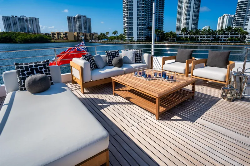 Santosh Yacht Photos Pics Luxurious deck seating on a 2020 Majesty 100 yacht with cityscape views.
