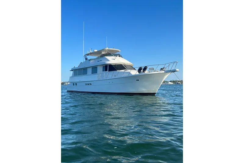 Moon River Yacht Photos Pics 1997 Hatteras 70 Sport Deck Motor Yacht on calm water under clear blue sky.