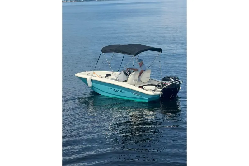 Moon River Yacht Photos Pics Small motorboat "T/T Moon River" with canopy on calm water, featuring a Mercury 40 engine.