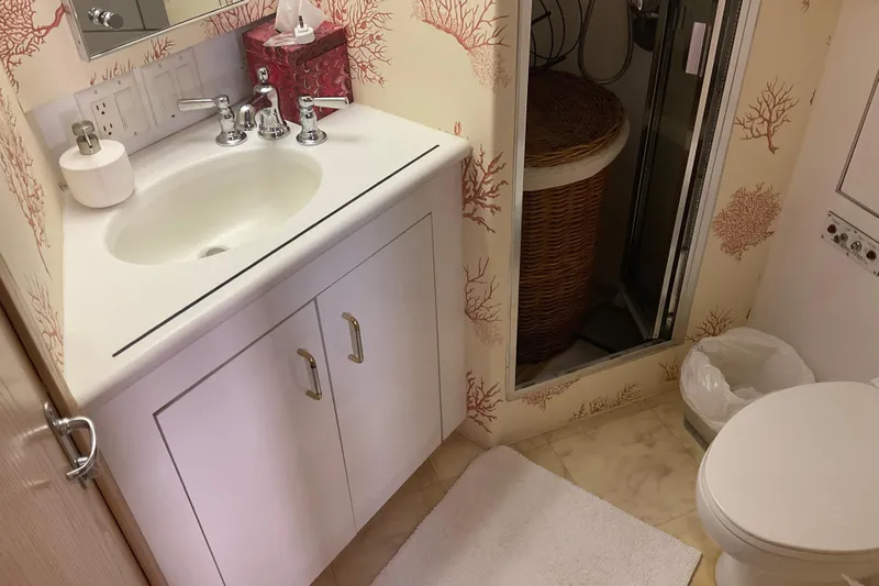 Moon River Yacht Photos Pics Bathroom interior of 1997 Hatteras 70 Sport Deck Motor Yacht with coral-themed wallpaper.
